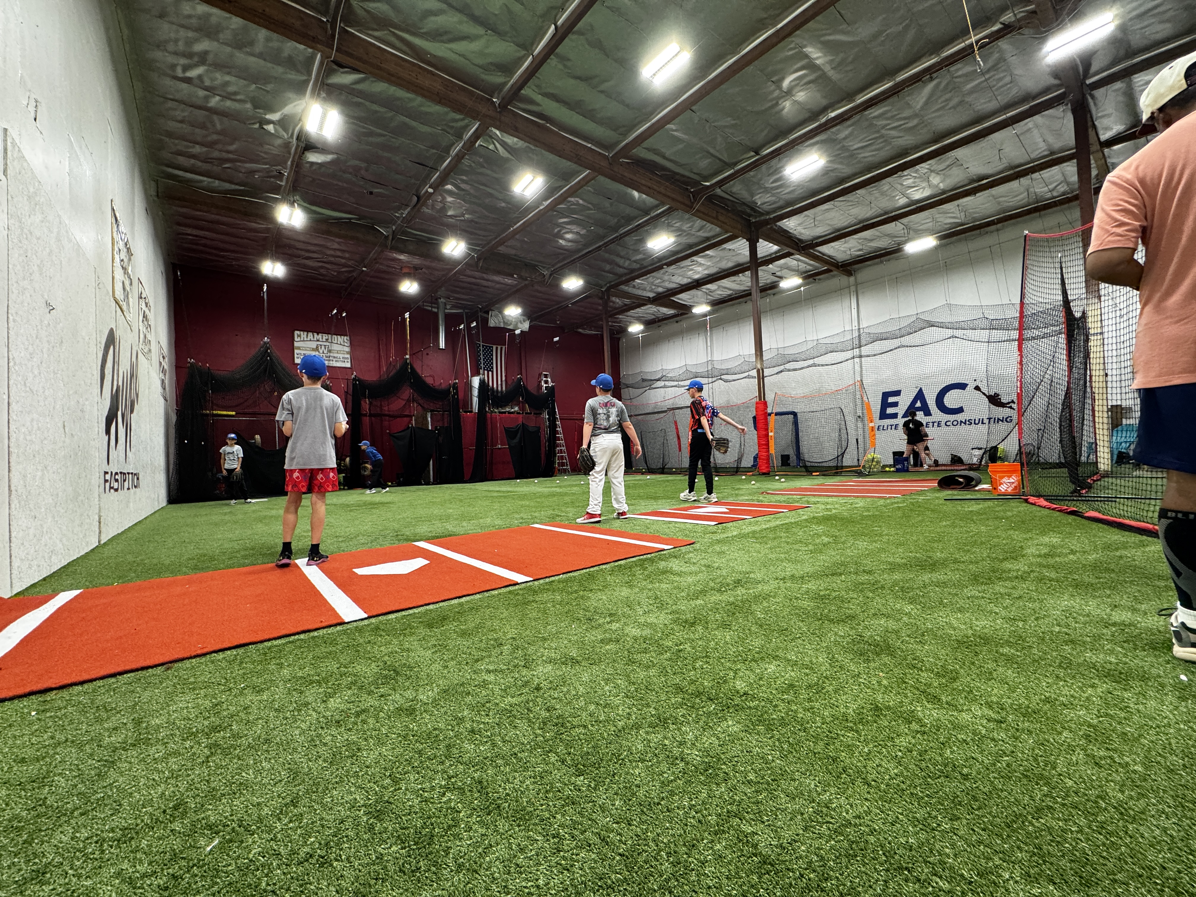 Youth athletes practicing on indoor fielding turf